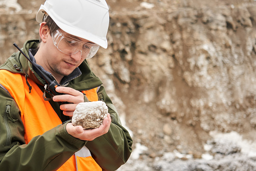 man geologist examines a mineral sample