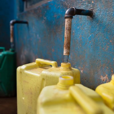 Yellow plastic jerry cans filling at water kiosk in Rwanda